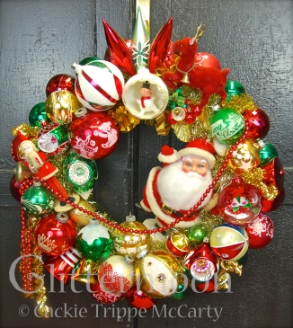 A HO HO HO of a wreath in traditional reds & greens with a big jolly Santa as centerpiece, joined by a marvelous little Japan Belsnickel, and so much more! $250 ** SOLD**
